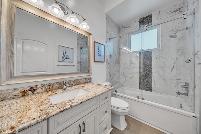 full bathroom featuring toilet, tiled shower / bath combo, and vanity