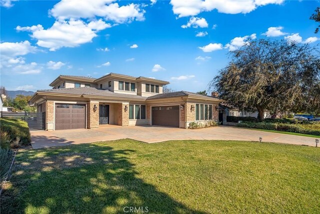 prairie-style home featuring a front yard and a garage