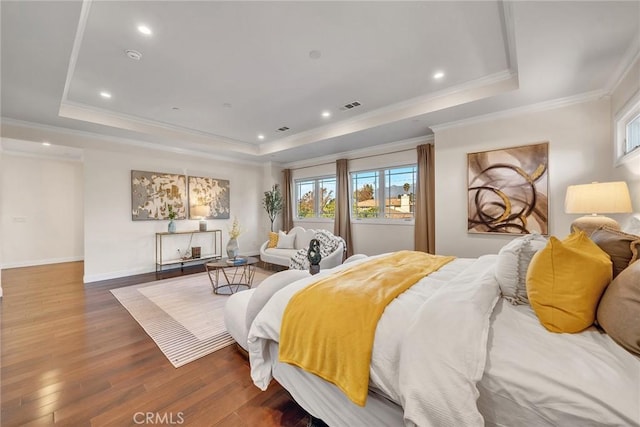 bedroom with dark wood-type flooring, a tray ceiling, and ornamental molding