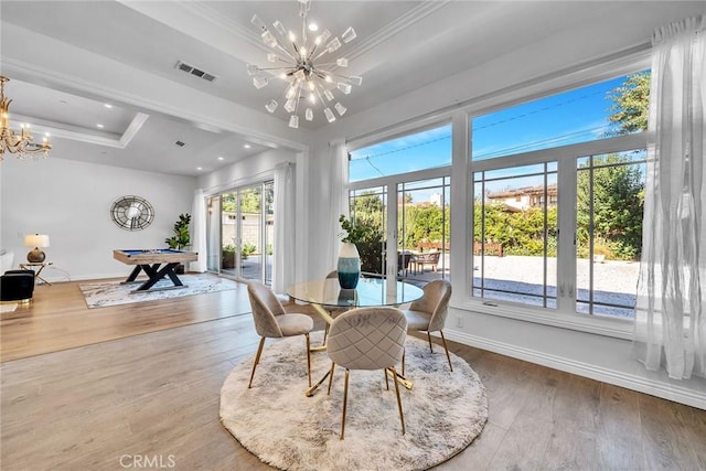 dining space with a wealth of natural light, a chandelier, hardwood / wood-style flooring, and a tray ceiling