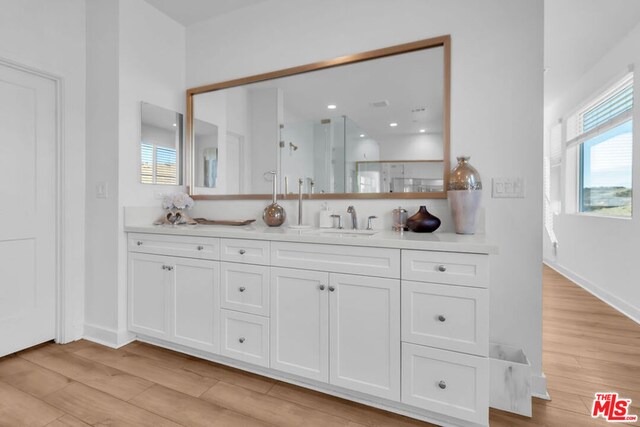 bathroom featuring a shower with door, wood-type flooring, and vanity