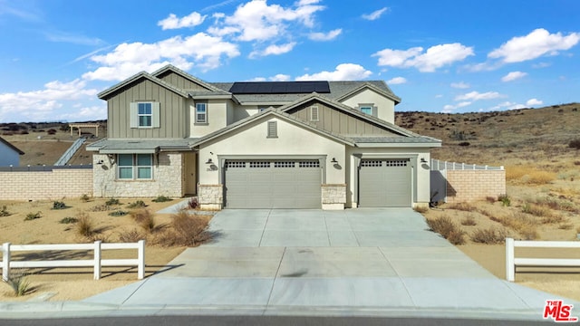 craftsman-style home featuring a garage and solar panels