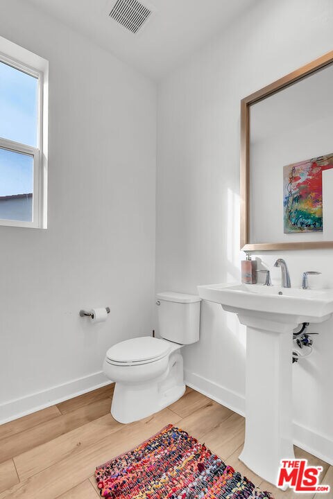 bathroom featuring wood-type flooring and toilet