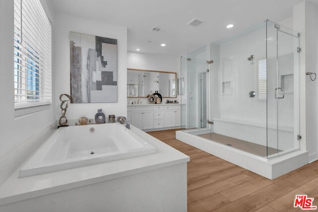 bathroom with vanity, shower with separate bathtub, and hardwood / wood-style flooring