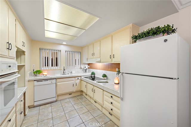 kitchen featuring sink, white appliances, cream cabinets, and light tile patterned floors