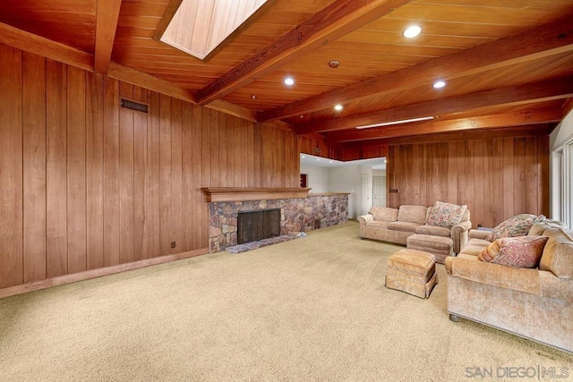 living room featuring beam ceiling, a fireplace, and wood walls