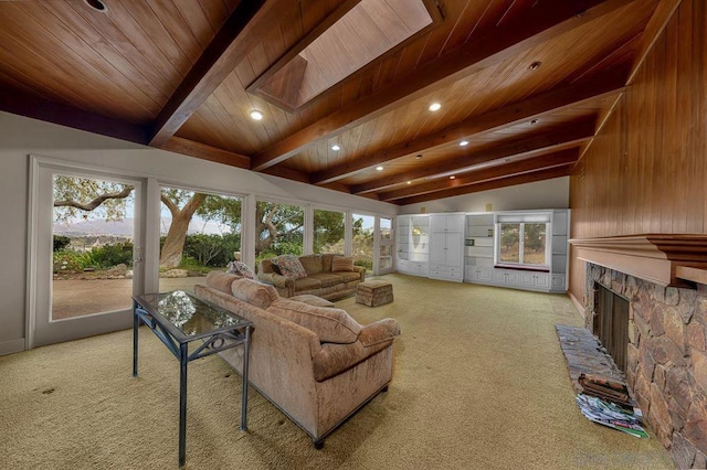 carpeted living room featuring wooden ceiling, a healthy amount of sunlight, a fireplace, and vaulted ceiling with beams