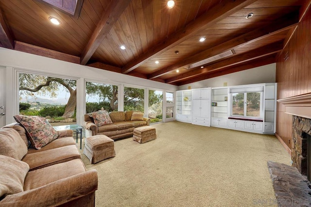 living room featuring lofted ceiling with skylight, light carpet, and a fireplace