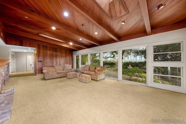 unfurnished living room with carpet flooring, beamed ceiling, wood walls, and wooden ceiling