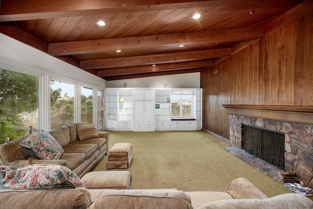 carpeted living room with vaulted ceiling with beams, wood walls, wood ceiling, and a fireplace