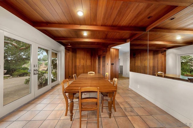 tiled dining area with wooden ceiling, a wealth of natural light, and wood walls