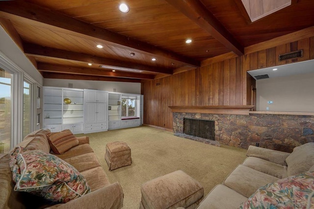 living room featuring a stone fireplace, beamed ceiling, wood walls, and carpet flooring