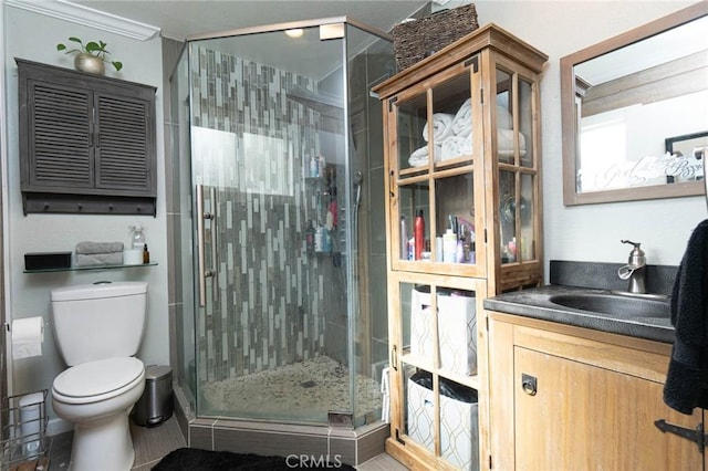 bathroom featuring tile patterned floors, toilet, vanity, and walk in shower