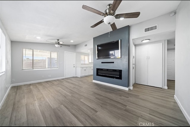 unfurnished living room with hardwood / wood-style floors, a wealth of natural light, and a fireplace