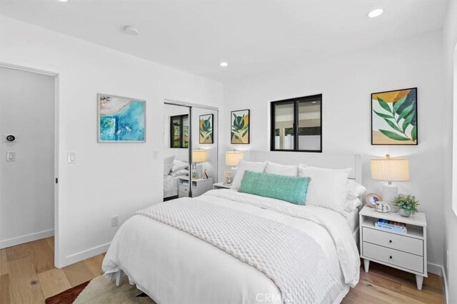 bedroom with light wood-type flooring and a closet