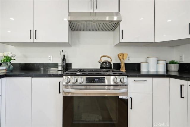 kitchen featuring gas stove, white cabinets, and wall chimney range hood