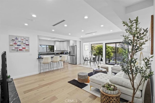 living room featuring a wealth of natural light and light hardwood / wood-style flooring