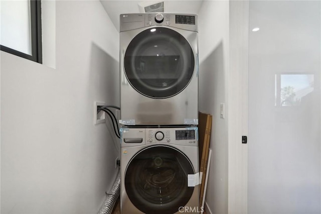 clothes washing area with stacked washer / dryer