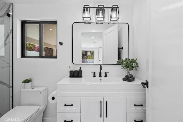 bathroom with toilet, vanity, and a shower with shower door