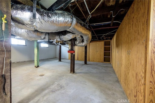 basement featuring wooden walls