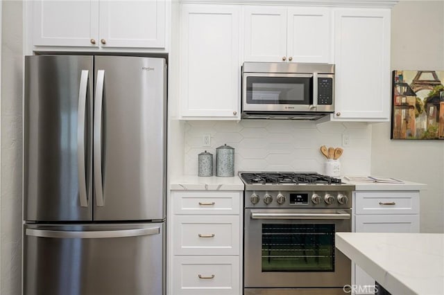 kitchen featuring stainless steel appliances, decorative backsplash, and white cabinetry