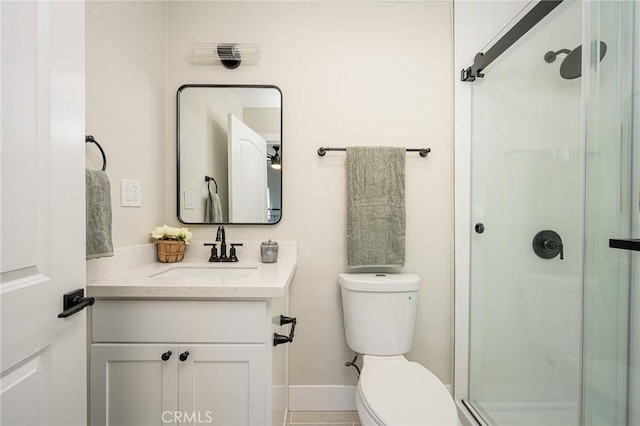 bathroom featuring toilet, vanity, and a shower with door