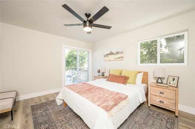 bedroom featuring access to outside, ceiling fan, and dark wood-type flooring