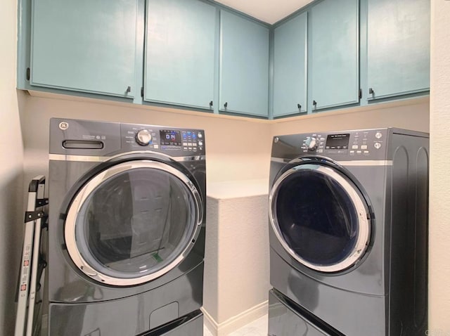 laundry area featuring washer and dryer and cabinets