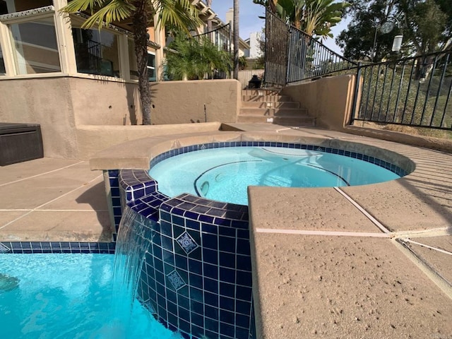 view of pool with pool water feature and an in ground hot tub