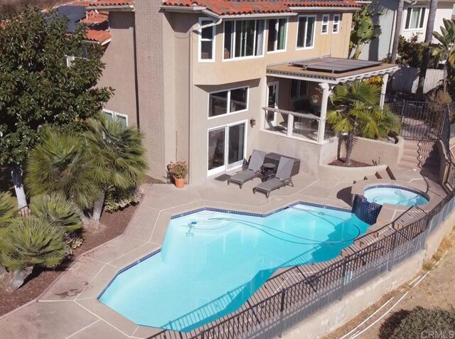 view of swimming pool featuring a patio area and an in ground hot tub