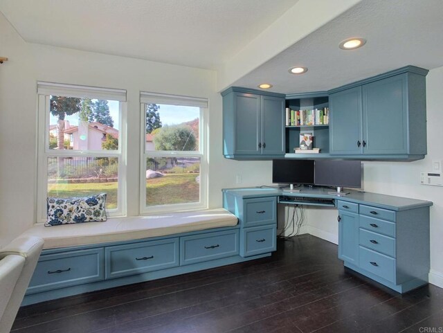 home office with dark hardwood / wood-style floors and built in desk