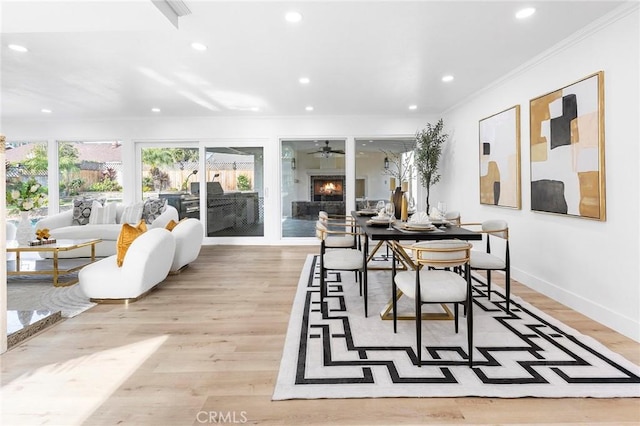 dining area featuring ceiling fan, ornamental molding, and light hardwood / wood-style flooring