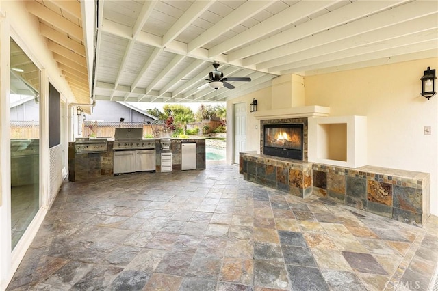 view of patio / terrace featuring ceiling fan, a tiled fireplace, a grill, and area for grilling