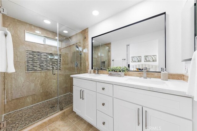 bathroom featuring vanity and a shower with door