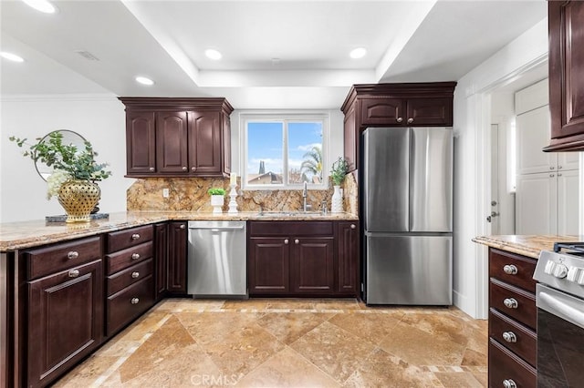 kitchen with appliances with stainless steel finishes, backsplash, ornamental molding, light stone counters, and sink