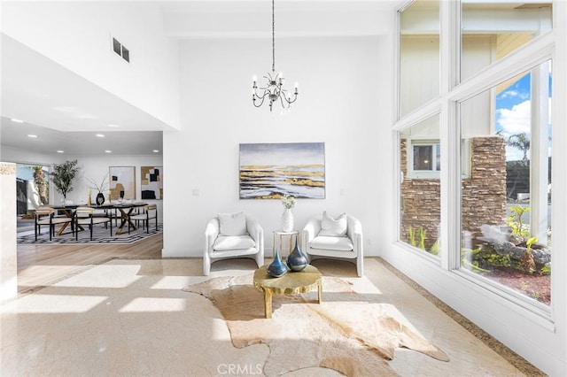 living area featuring a towering ceiling and a notable chandelier