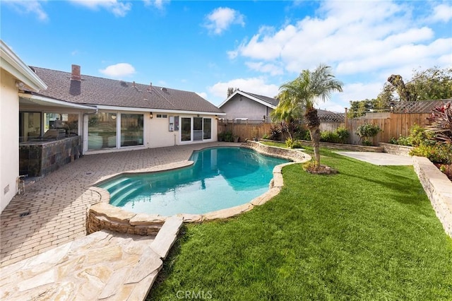 view of pool with a patio area and a yard