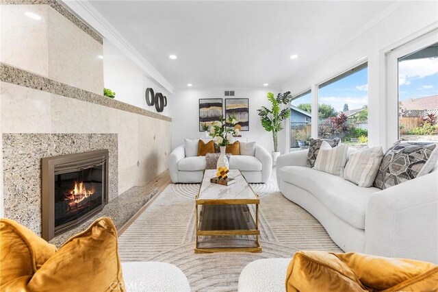 living room with ornamental molding and a fireplace