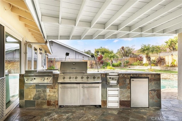 view of patio / terrace featuring an outdoor kitchen, a fenced in pool, and area for grilling