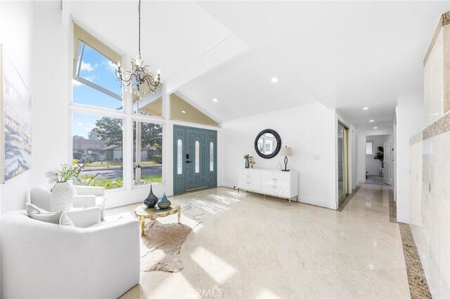 living room featuring high vaulted ceiling and a notable chandelier