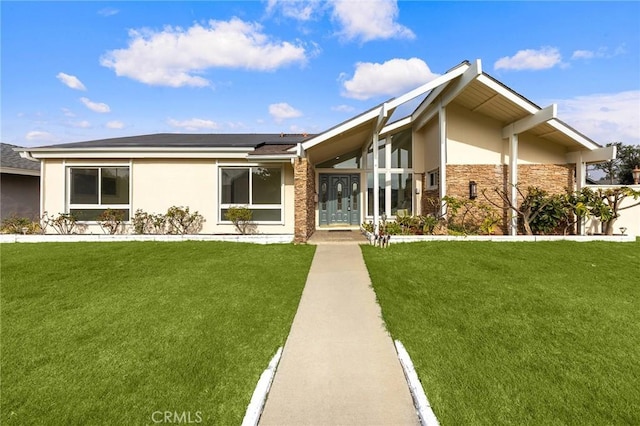 view of front facade with a front yard and solar panels