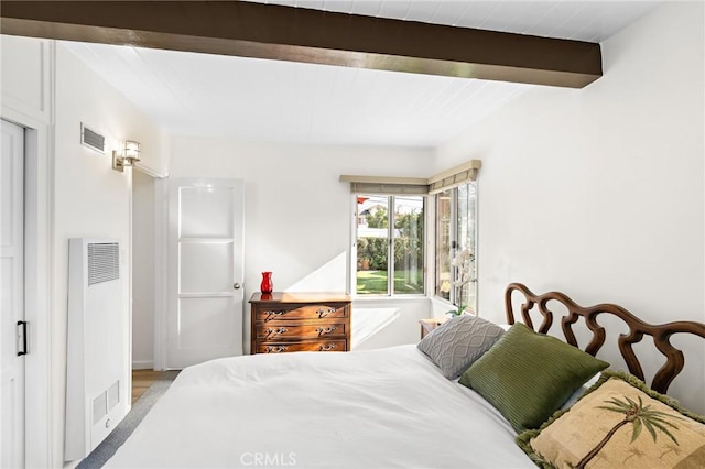 bedroom with beamed ceiling and visible vents