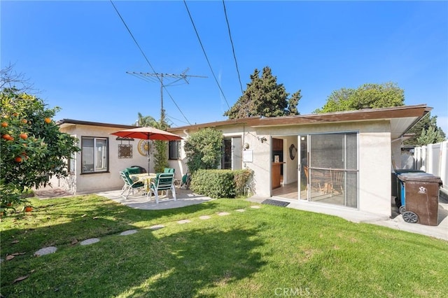 back of house featuring stucco siding, a patio, a yard, and fence