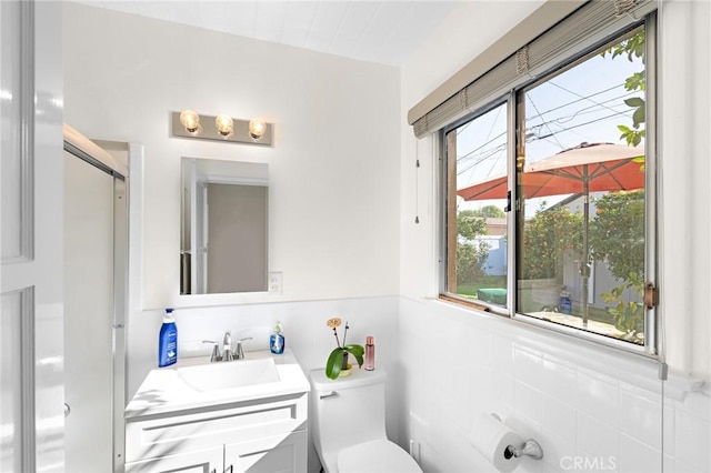 bathroom with a shower with door, toilet, and vanity