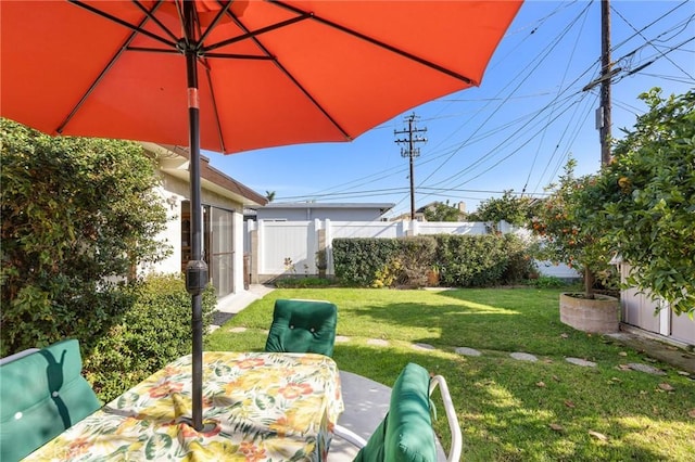 view of yard with outdoor dining space and fence