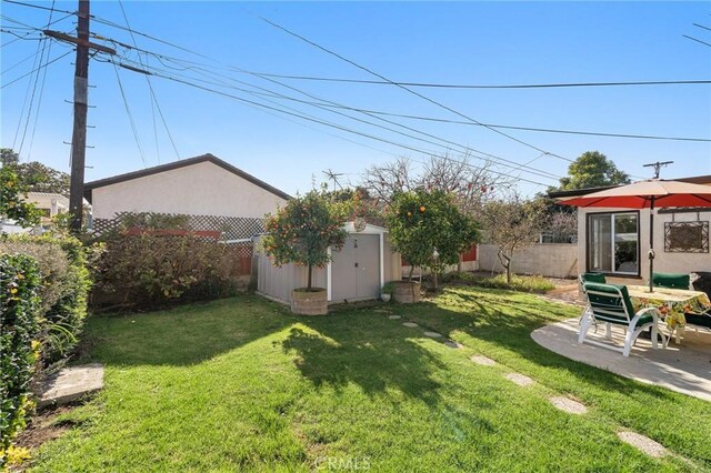 view of yard with a storage shed and a patio area