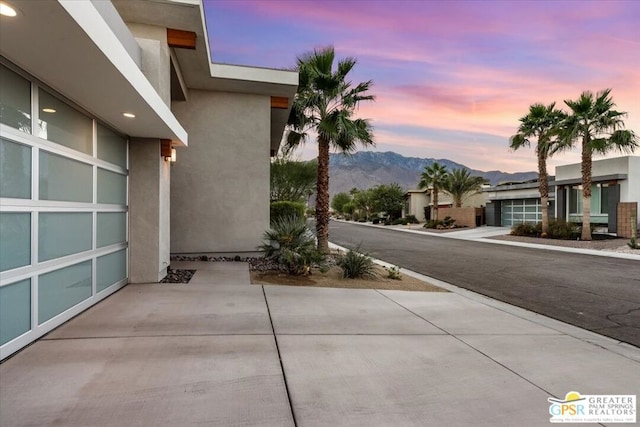 patio terrace at dusk featuring a mountain view