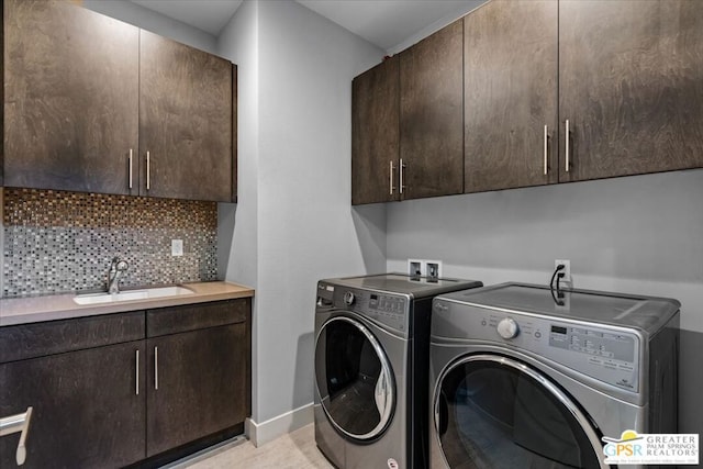 washroom with washing machine and dryer, sink, and cabinets