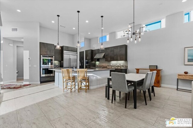 dining room with sink and a towering ceiling