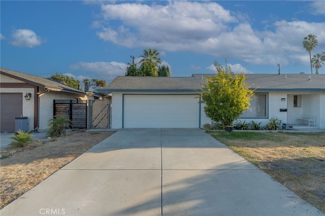 ranch-style home with a garage and central AC